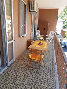 a patio with a table and chairs on a balcony at VRENI LODGE in Finale Ligure