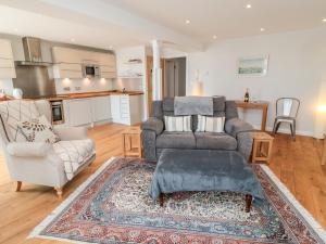 a living room with a couch and a chair at 5 Mill Wharf in Berwick-Upon-Tweed