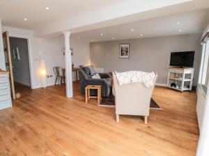 a living room with a couch and a chair at 5 Mill Wharf in Berwick-Upon-Tweed