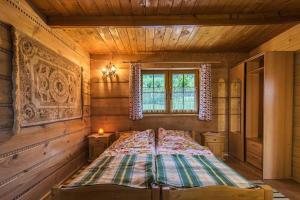 una camera con un letto in una baita di tronchi di Domki Bacówka Pod Skocznią a Zakopane