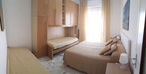 a small bedroom with two beds and a window at VRENI LODGE in Finale Ligure