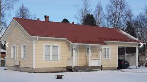 a small house with a red roof in the snow at Apartment Sorsakuja in Pyhäjoki