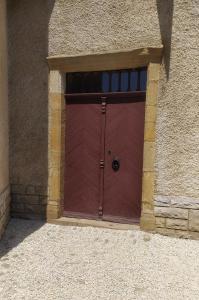 a red garage door in a brick building at Gîte château d'Espalungue, piscine et SPA in Dognen