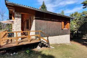 a small log cabin with a porch and an umbrella at Chalet privé au Mont-Serein ventoux in Mont Serein