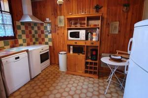 uma cozinha com um fogão, um micro-ondas e uma mesa em Chalet privé au Mont-Serein ventoux em Mont Serein