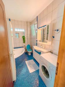 a bathroom with a tub sink and a washing machine at Dream Villa in Paleo Tsifliki +30 photos