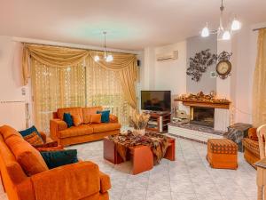 a living room with orange furniture and a fireplace at Dream Villa in Paleo Tsifliki