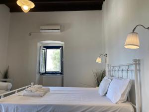 a white bedroom with a bed with towels on it at Drymonas Heights Kythira Traditional Volto in Kýthira