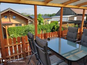 eine Terrasse mit einem Glastisch und Stühlen auf einer Terrasse in der Unterkunft Spreewaldhäuser Wiesner in Lübbenau