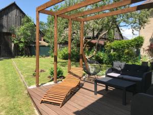 a wooden pergola with a couch and a table on a deck at Privat in Liptovský Ján