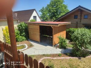 una casa de perros de madera en el patio trasero de una casa en Spreewaldhäuser Wiesner, en Lübbenau