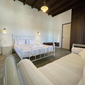 a white bedroom with two beds and a bath tub at Drymonas Heights Kythira Traditional Volto in Kýthira