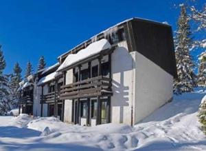 a building covered in snow in the snow at Apartma Svizec Rogla in Zreče