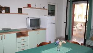 a kitchen with a table with a television on a counter at Trilocale Sissy sul mare in Gallipoli