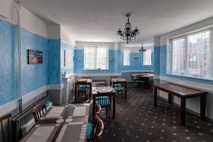 uma sala de jantar com paredes azuis e mesas e cadeiras em The Old Castle Hotel em Rodwell
