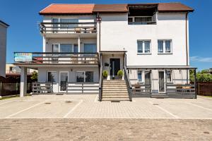 a large white building with a balcony and stairs at Marinas Rewa in Rewa