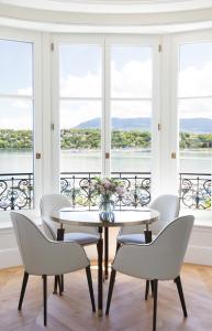 a dining room with a table and chairs and windows at The Woodward - an Oetker Collection Hotel in Geneva