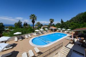 a swimming pool with chairs and umbrellas on a resort at Hotel Penelope in Boukari