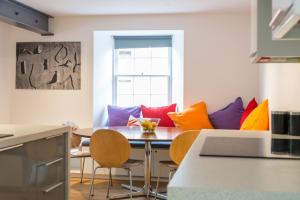 a kitchen with a table and chairs with colorful pillows at Charming 3 Bed Village Green Cottage East Lothian in Gifford