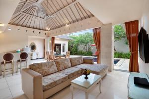a living room with a couch and a table at Kaisa Villas Seminyak in Seminyak