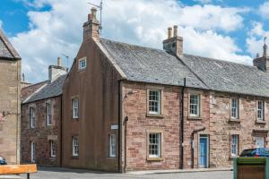ein altes Backsteingebäude mit grauem Dach in der Unterkunft Charming 3 Bed Village Green Cottage East Lothian in Gifford
