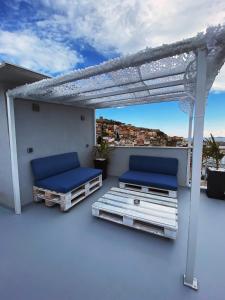 uma varanda com 2 camas e uma pérgola em Alto Suite (Cielo suites) em Kavala