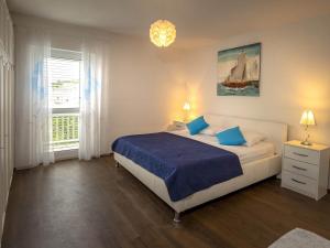 a bedroom with a bed with blue sheets and a window at Apartments Snjezana in Povlja