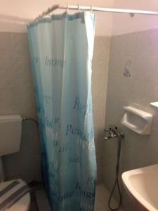 a bathroom with a shower curtain with writing on it at Hotel Maria-Elena in Agios Kirykos