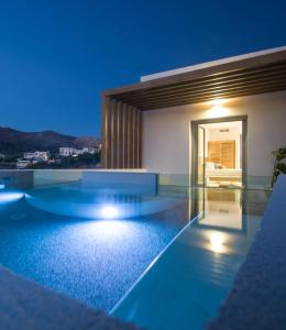 a villa with a swimming pool at night at Oro Suites in Kinion