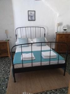 um quarto com uma cama preta e almofadas azuis em Casa Alice em Salar