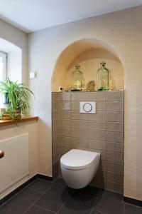 La salle de bains est pourvue de toilettes et de 2 bocaux en verre. dans l'établissement Ferienhaus Eifel 1851, à Gipperath