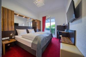 a hotel room with a bed and a flat screen tv at FF&E Hotel Engeln in Papenburg