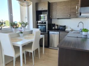 a kitchen with a white table and white chairs at Pae külaliskorter in Kärdla