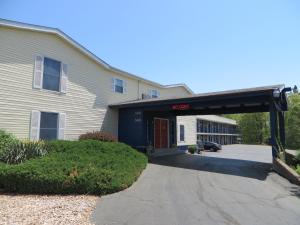 un edificio con un garaje delante de él en Scottish Inns Motel - Osage Beach en Osage Beach