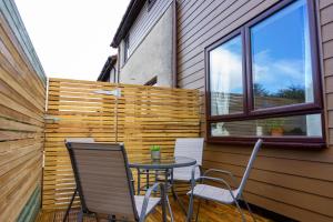 a patio with a table and chairs and a fence at Stunning one bedroom accommodation in Oban