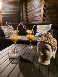 una mesa de centro con dos vasos de zumo de naranja y una cabeza en L'embrun de jasmin, en Beaumont