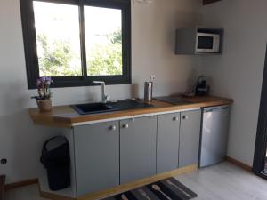 a kitchen with a sink and a window at L'embrun de jasmin in Beaumont