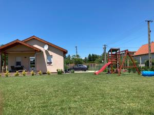 a yard with a slide and a playground at Konrad Apartman in Balatonmáriafürdő