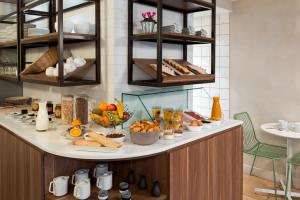 a breakfast buffet with bread and other food on a counter at Hôtel Sanso by HappyCulture in Paris