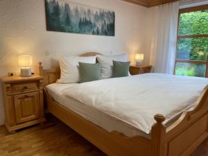 een slaapkamer met een bed met witte lakens en 2 lampen bij Ferienwohnungen Alpentraum - Tiefengrün und Tiefenblau in Oberstdorf