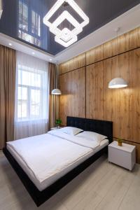 リヴィウにあるLEOGRAND VIP Apartments on Pidhirna 3の大きなベッドと木製の壁が備わるベッドルーム1室が備わります。
