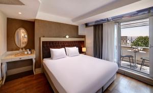 a bedroom with a large bed and a balcony at Faros Hotel Old City - Special Category in Istanbul