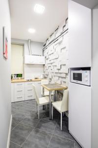 a kitchen with a table and white appliances at LEOGRAND VIP Apartments on Pidhirna 3 in Lviv