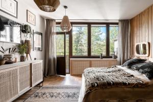 um quarto com uma cama e uma grande janela em Ethnica Apart Gallery em Zakopane