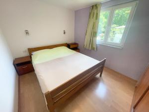 Bett in einem Zimmer mit Fenster in der Unterkunft Apartmani Matković in Jadranovo