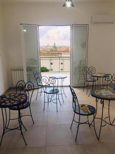 Habitación con mesas, sillas y ventana grande. en B&B Bellavista en Palermo