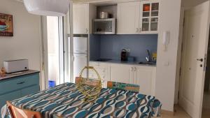 a kitchen with white cabinets and a table in a room at Apartamento céntrico cerca de la playa in L'Ametlla de Mar