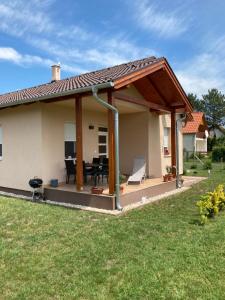 a house with a patio with a roof at Konrad Apartman in Balatonmáriafürdő