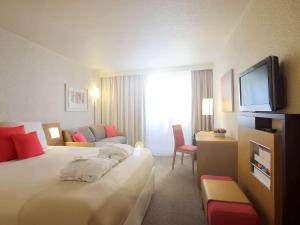 
A bed or beds in a room at Novotel Poissy Orgeval
