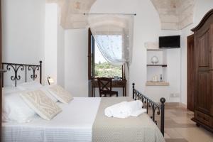 a bedroom with two beds and a window at Masseria Donna Nina in Ostuni +109 photos